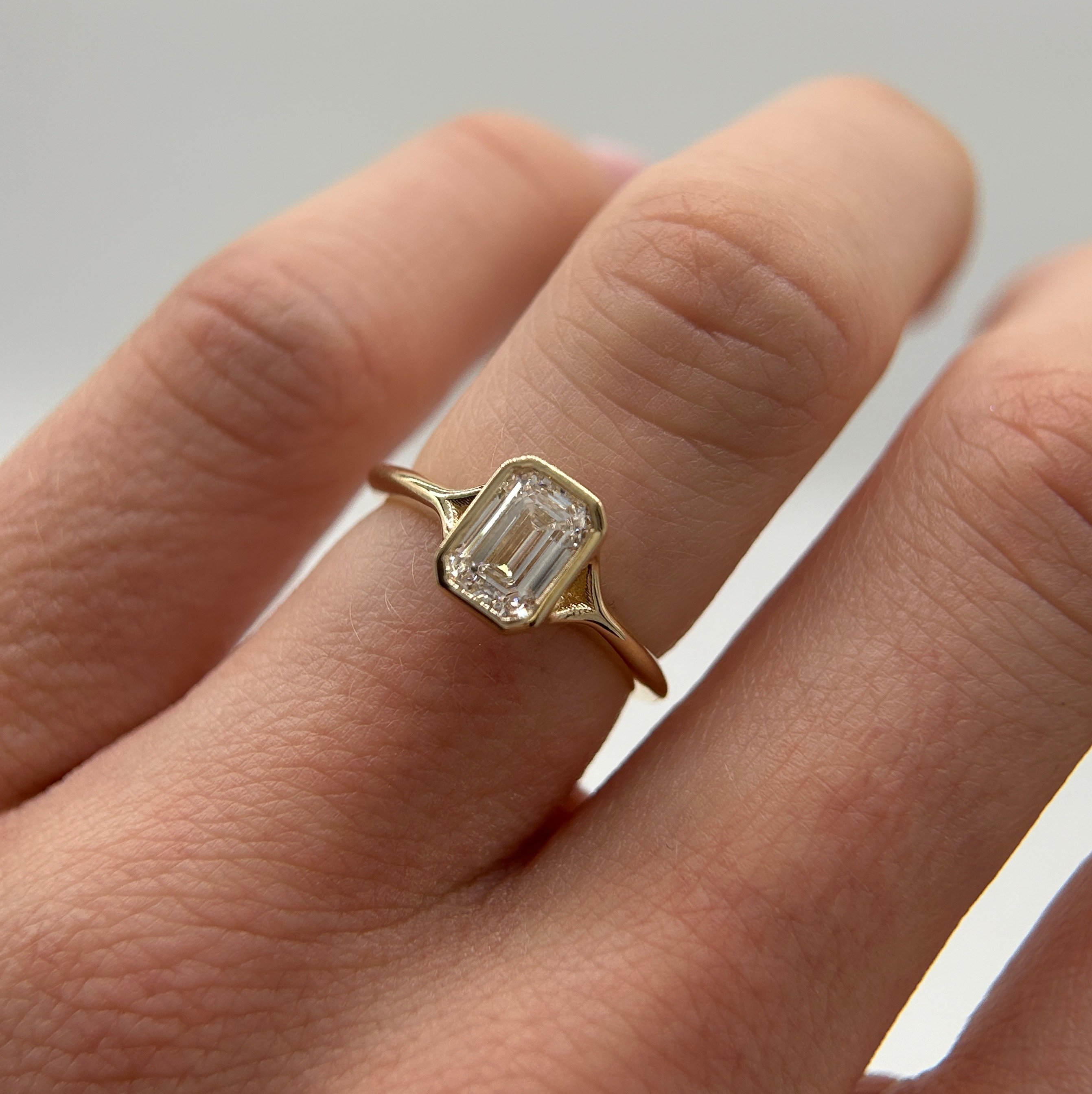 emerald cut engagement ring bezel set yellow gold
