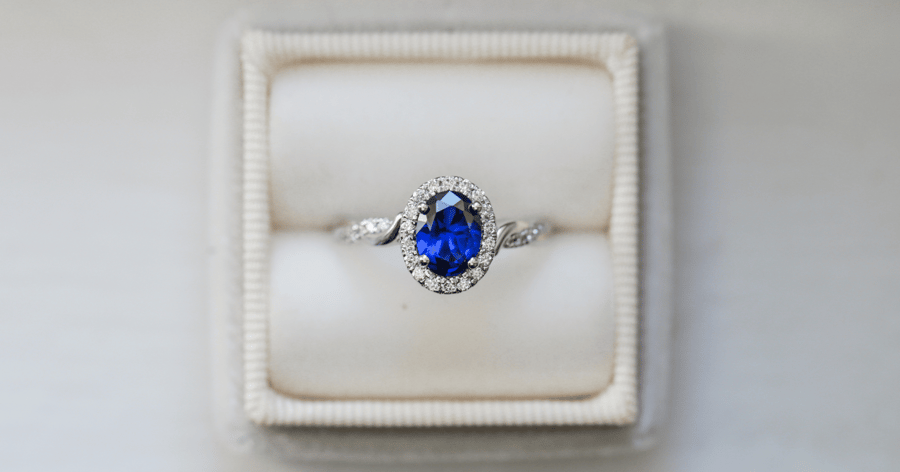 70s - White Gold (or Platinum) Diamond Halo Engagement Ring with a Twisted Shank and Pavé Accent Stones set with an Oval Cut Sapphire