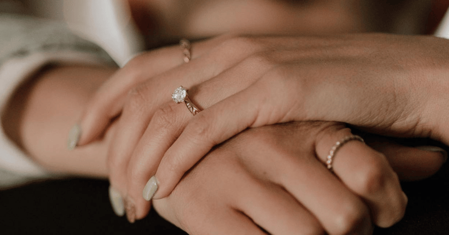 Female_hands_showing_round_engagement_ring_with_custom_engraving_work_on_band