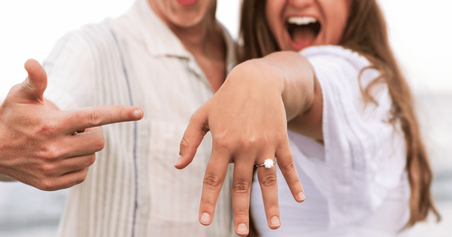 Happy_Engaged_Couple_Showing_Engagement_Ring_on_ring_finger