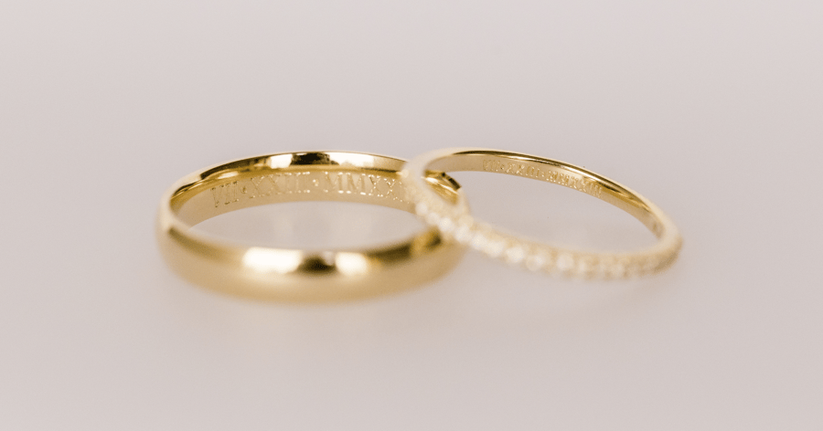 His_and_hers_yellow_gold_wedding_bands_showing_matching_personal_roman_numeral_engravings