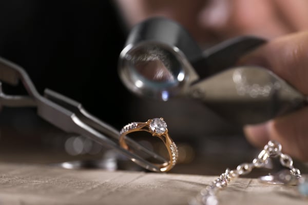 Male jeweler examining diamond ring in workshop