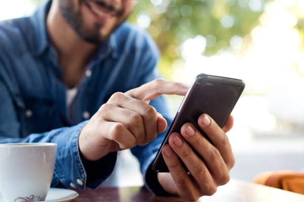 Modern young man with mobile phone in the street. doing online consultation