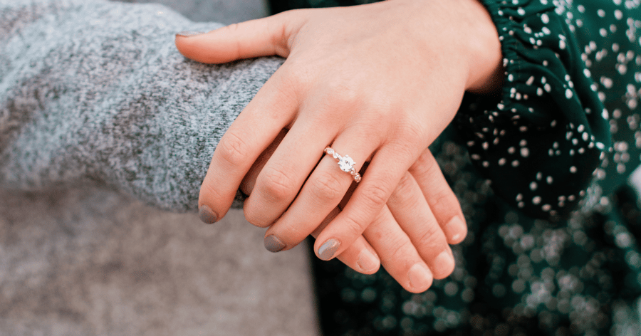 Rose Gold Accented Engagement Ring set with a Round Cut Diamond shown on Left Hand Ring Finger