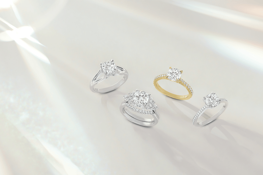Three_White_Gold_Rings_One_Yellow_Gold_Ring_with_Accenting_Diamonds_on_Reflective_Ivory_Background