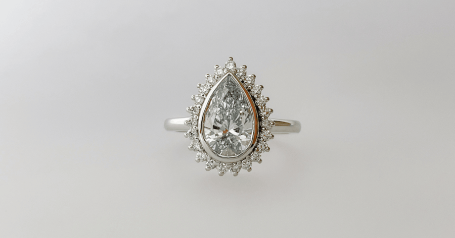 White Gold (or Platinum) Diamond Halo Engagement Ring Bezel set with a Pear Cut Diamond