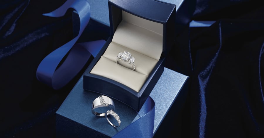 White_Gold_(or_Platinum)_Accented_Engagement_Ring_and_Matching_Wedding_Band_shown_with_Complementing_Mens_Wedding_Band_in_navy_blue_ring_box_with_ribbon