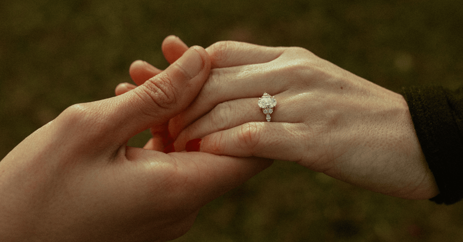 Yellow Gold Accented Engagement Ring set with an Oval Cut Diamond shown on Left Hand Ring Finger