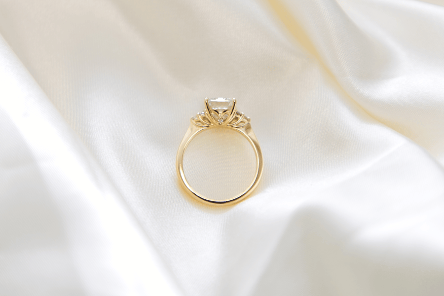 Yellow_Gold_Accented_Engagement_Ring_on_Ivory_Satin_Backdrop-2