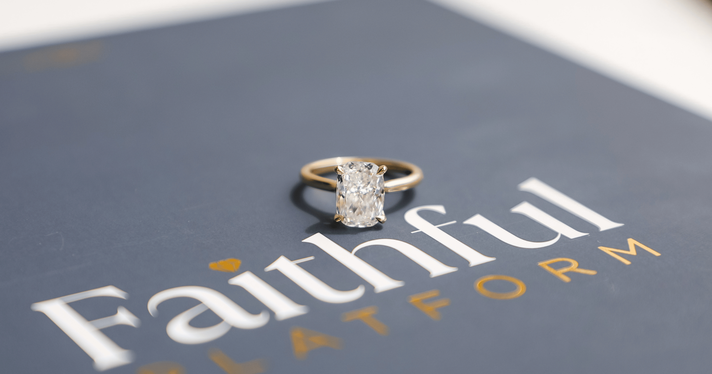 Yellow_gold_solitatire_elongated_cushion_cut_engagement_ring_on_Faithful_Platform_box