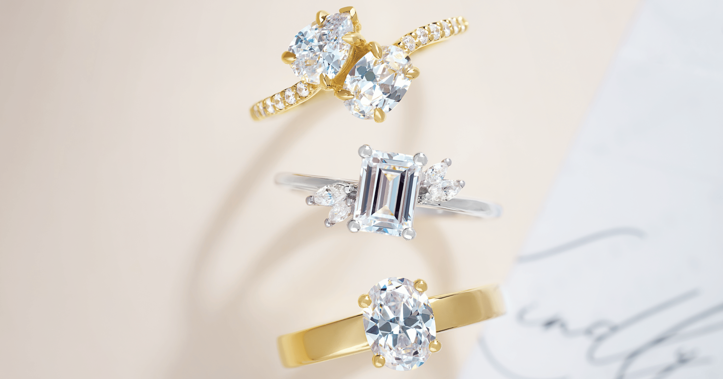 Yellow Gold Two Stone Engagement Ring with Accent Stones set with a Pear and Oval Cut Diamond; White Gold (or Platinum) Engagement Ring with Accent Stones set with an Emerald Cut Diamond; Yellow Gold Solitaire Engagement Ring set with an Oval Cut Diamond