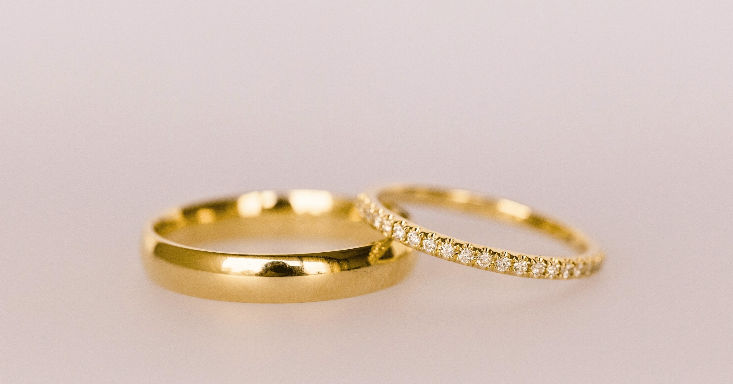 Yellow Gold Mens Wedding Band Next to Yellow Gold Diamond Studded Womens Wedding Band