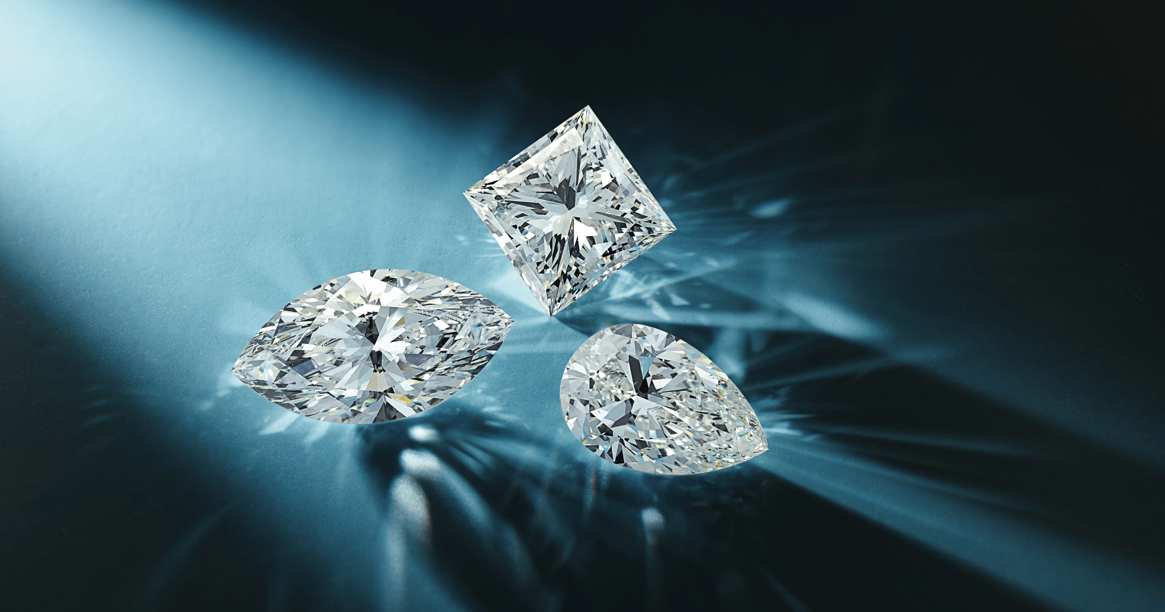 Loose Diamonds in Pear Marquise and Princess Cuts on Reflective Blue Background