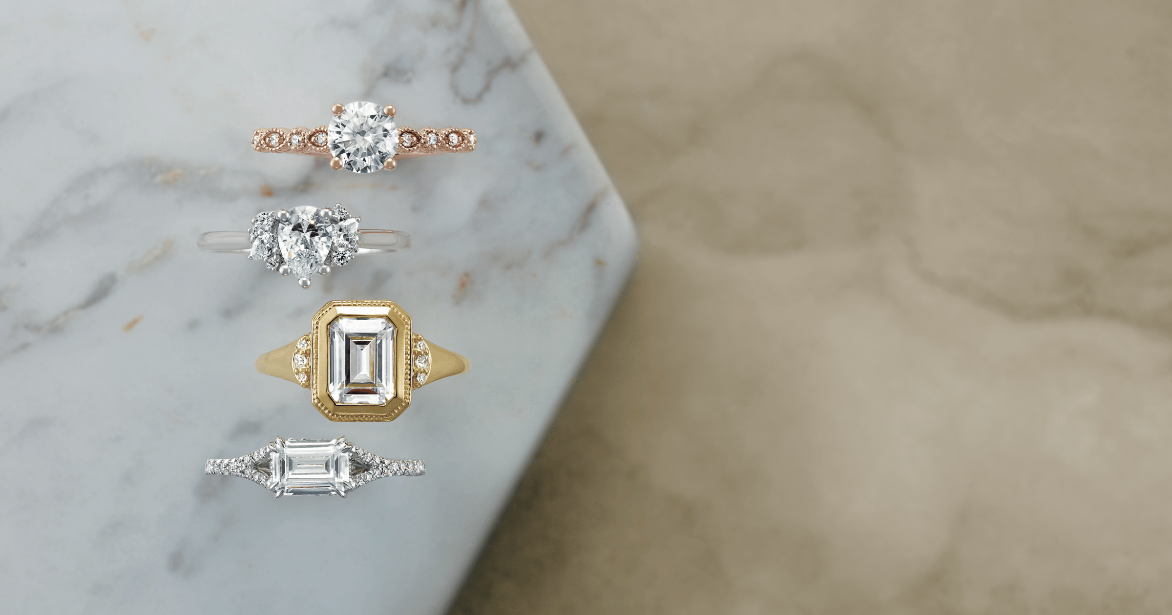 Rose Gold Accented Engagement Ring set with a Round Cut Diamond; White Gold (or Platinum) Accented Engagement Ring set with a Pear Cut Diamond; Yellow Gold Accented Engagement Ring set with an Emerald Cut Diamond; White Gold (or Platinum) Split Shank Accented Engagement Ring set with an Emerald Cut Diamond