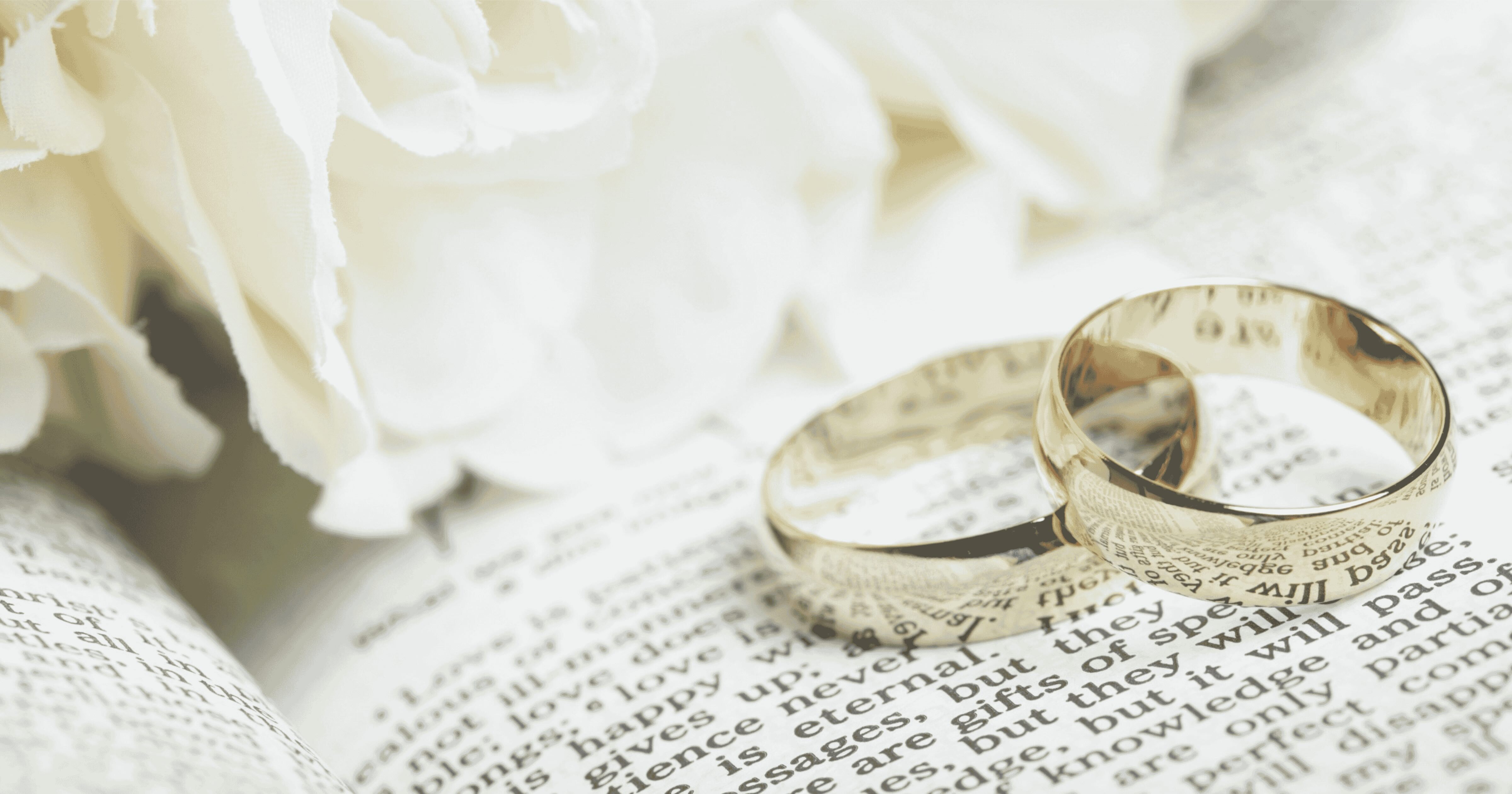Two Gold Wedding Bands Sitting on Book