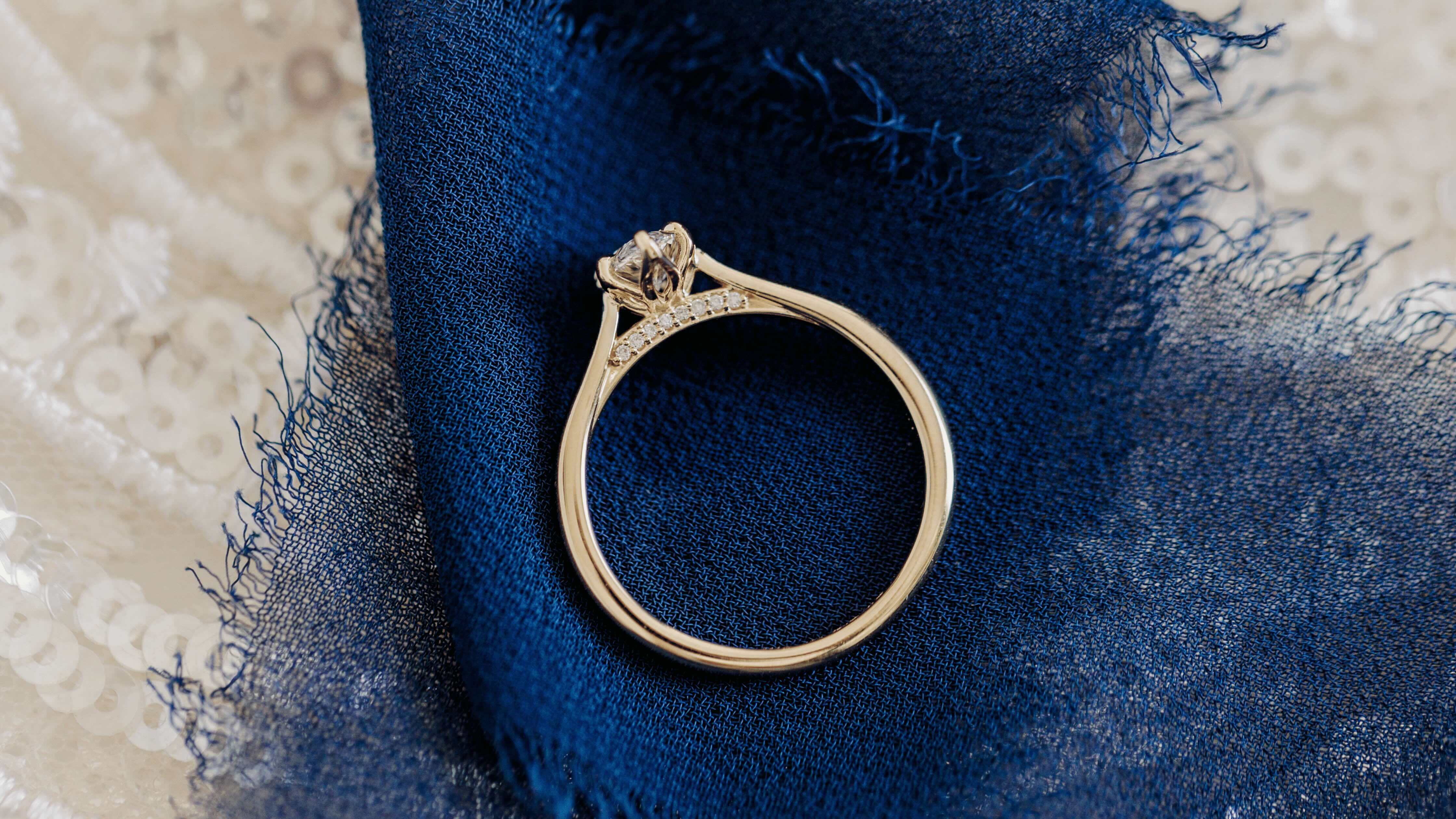 Yellow Gold Engagement Ring with Hidden Halo and Beautiful Accents on Navy Ribbon