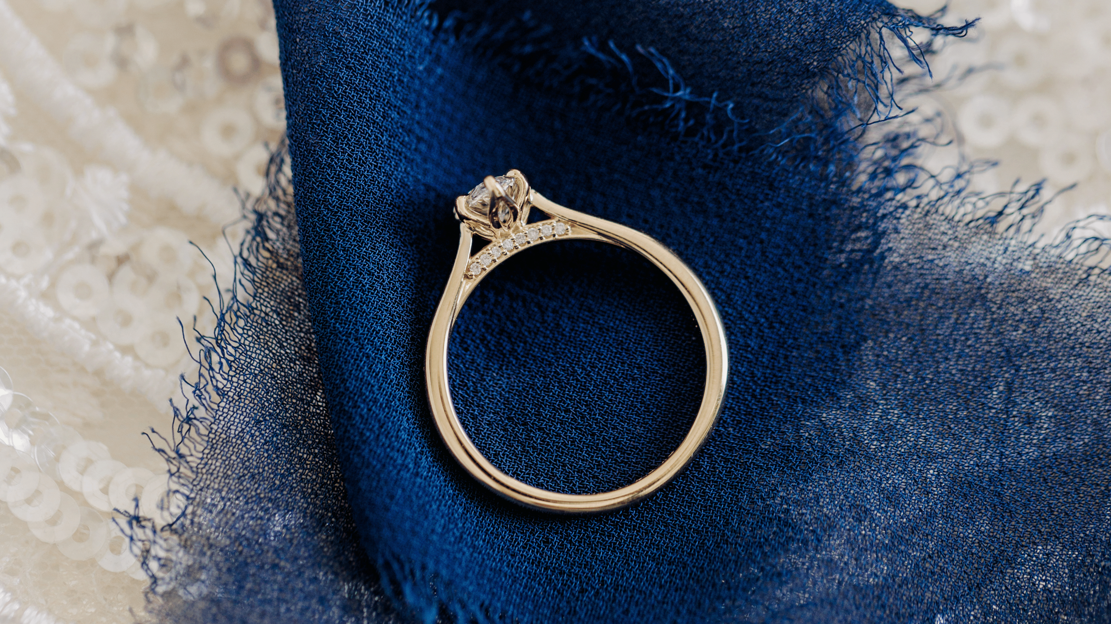 Yellow Gold Engagement Ring with Petal Prongs and Diamond Accents on the Bridge set with a Marquise Cut Diamond