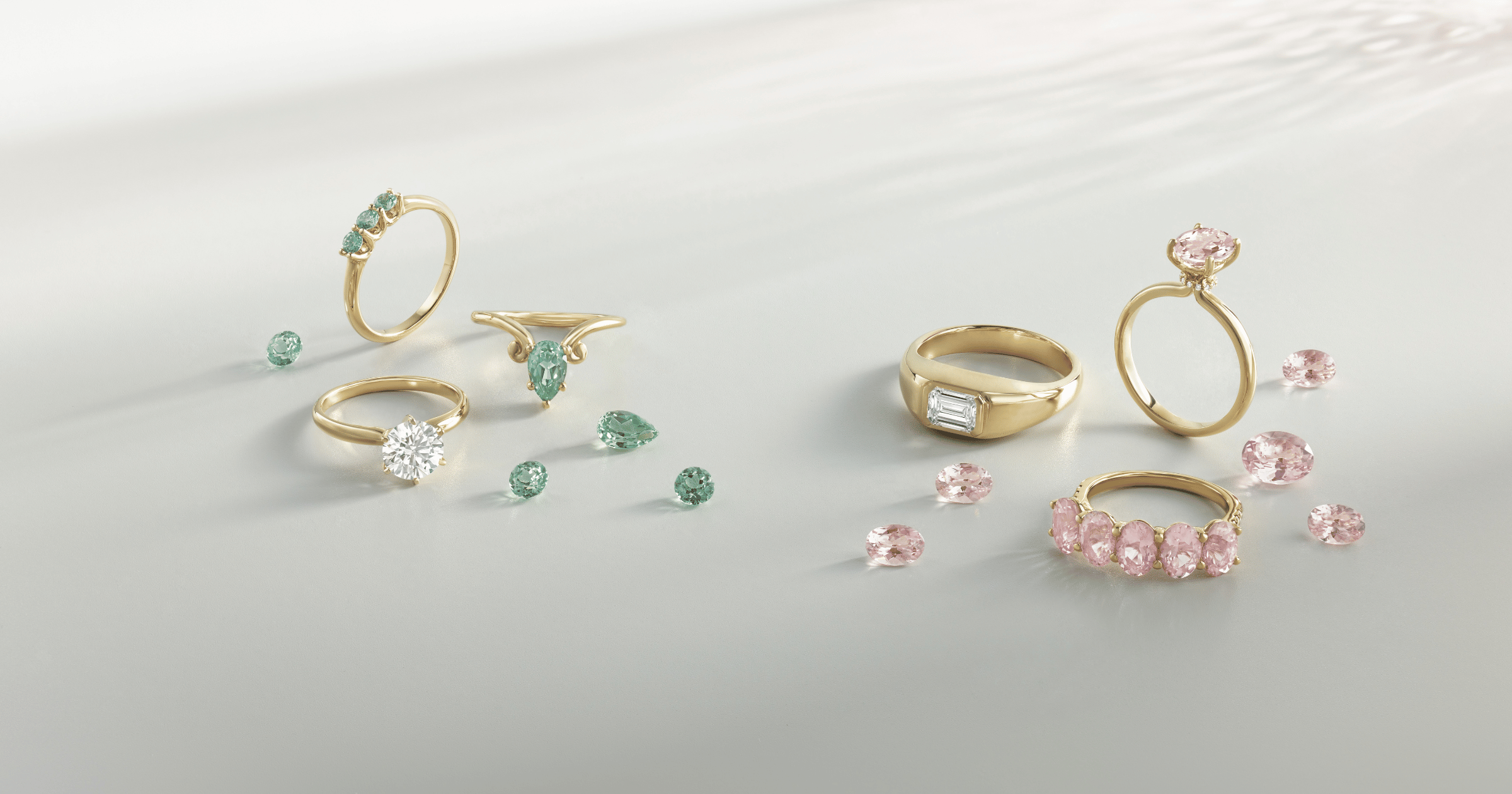 Yellow Gold Ring set with Round Green Stones; Yellow Gold Solitaire Engagement Ring set with a Round Cut Diamond; Yellow Gold Ring set with a Pear Green Stones; Yellow Gold Wedding Band set with an Emerald Cut Diamond; Yellow Gold Diamond Hidden Halo Ring set with Oval Pink Stone; Yellow Gold Ring set with Oval Pink Stones