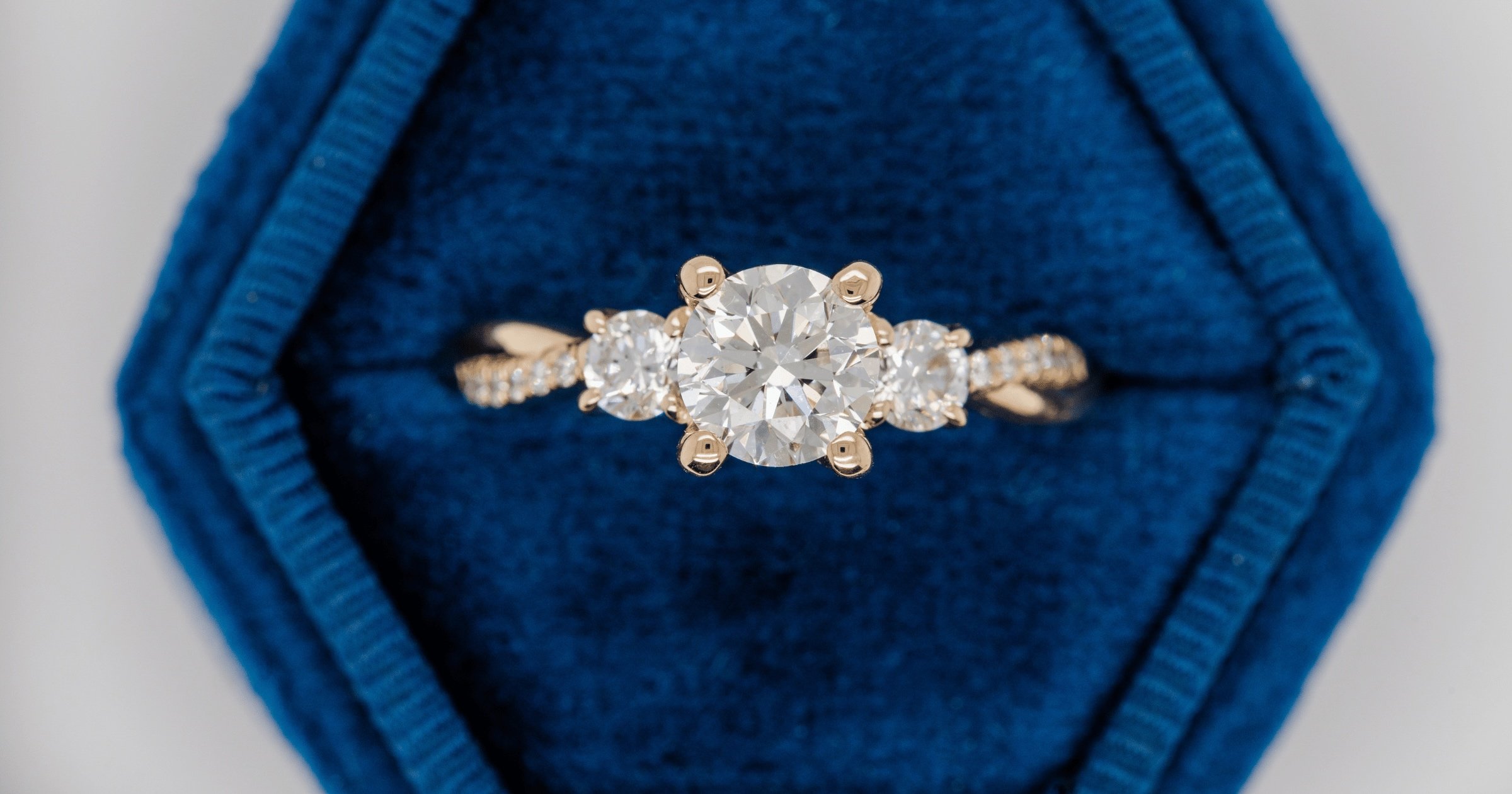 Yellow Gold Round Diamond Engagement Ring with Accenting Diamond Stones in Blue Velvet Box